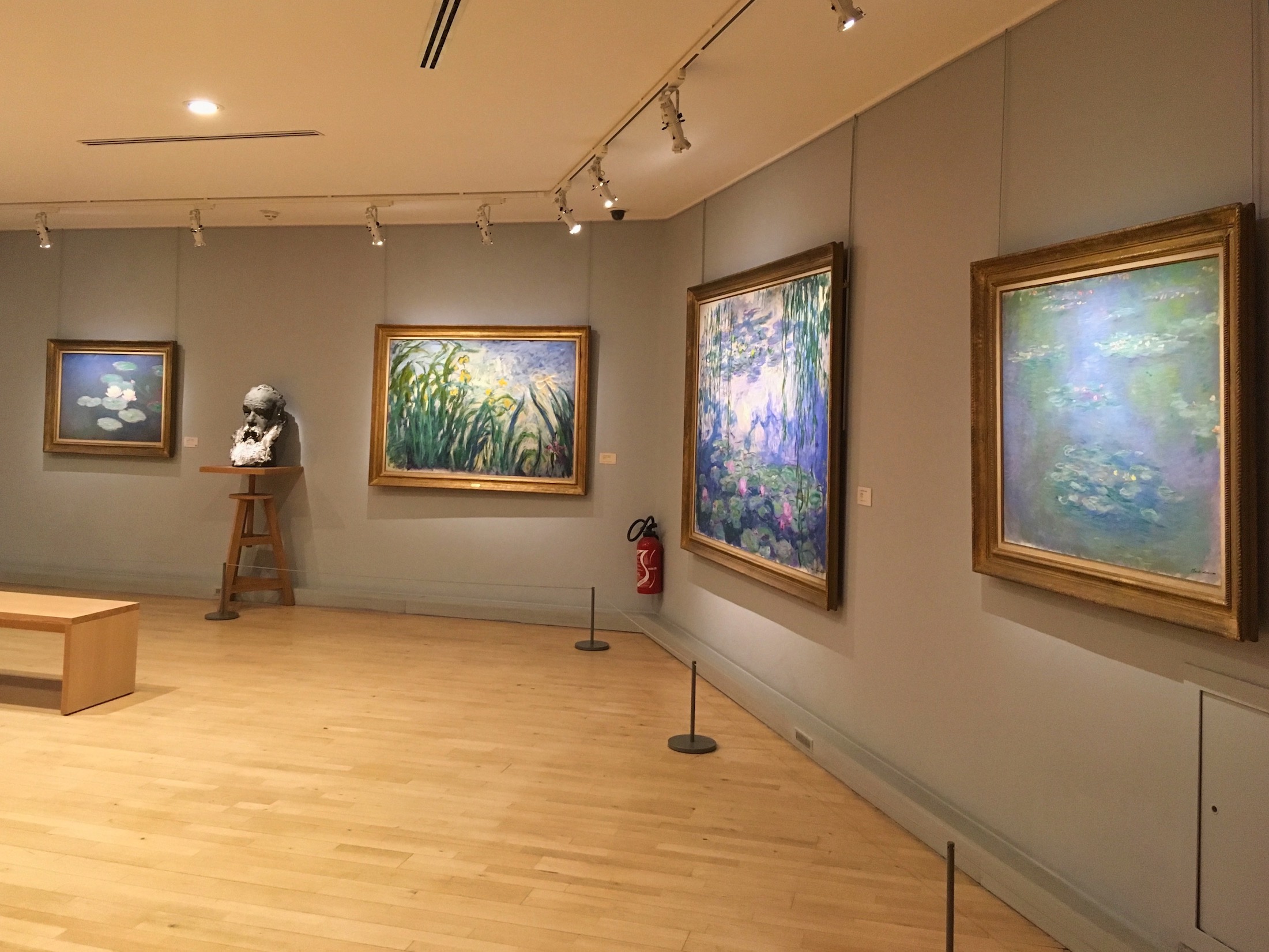 Four of Monet's water lilly paintings and a bust of the painter.