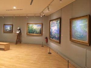 Four of Monet's water lilly paintings and a bust of the painter.