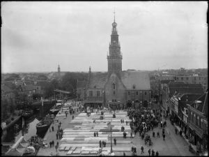 Circa 1932: Panorama from small waag to waag building during cheese market, Spekbrug, Houttil.